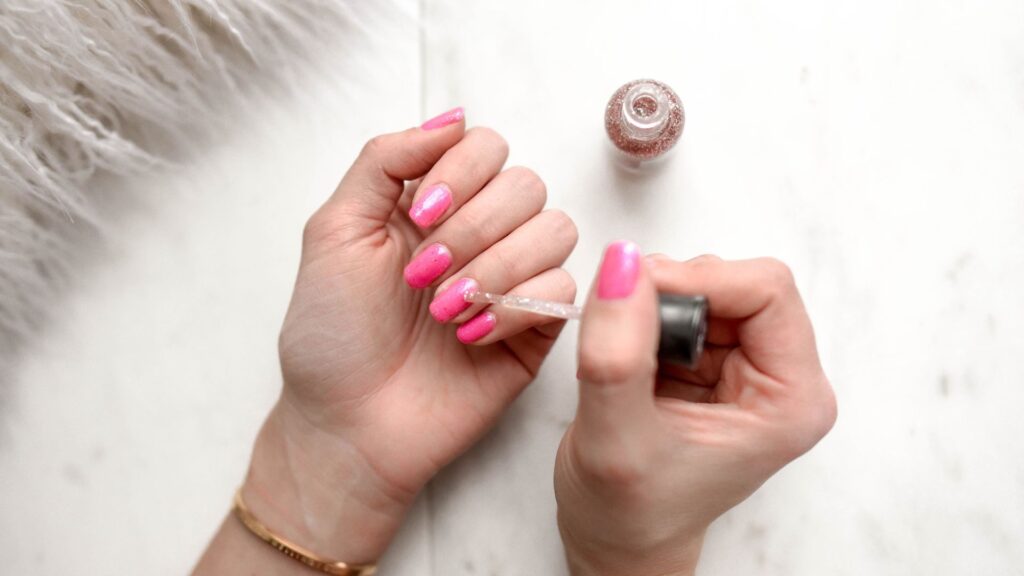 Cat Eye Nail Polish: My Honest Experience and Tips for Better Results 4 Applying pink cat eye nail polish with a top coat brush