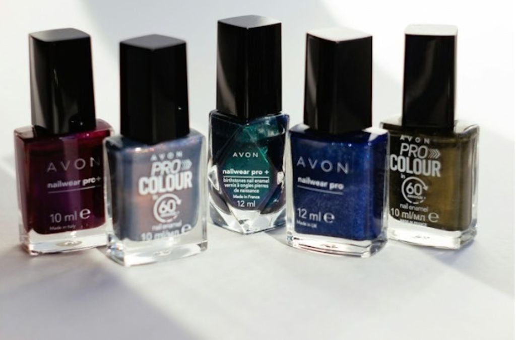 Collection of nail polish bottles in gray, teal, blue, and dark shades alongside burgundy nail polish color options.