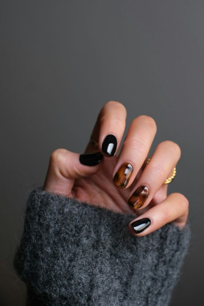 10 Easy Nail Art Ideas for Beginners You Can Try at Home 4 Easy Nail Art featuring glossy black nails with metallic gold accents and brown details.