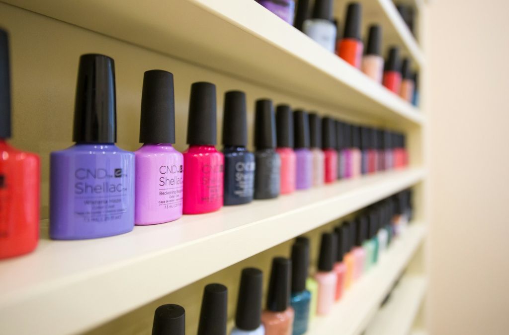 Best Nail Colors collection featuring pink, purple, blue, and neutral nail polish bottles displayed on shelves.