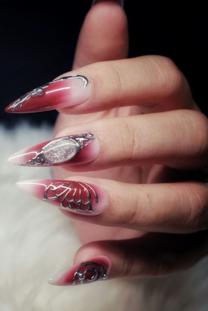 10 Easy Nail Art Ideas for Beginners You Can Try at Home 6 Easy Nail Art featuring long pointed nails with red polish, silver glitter, and swirl patterns.