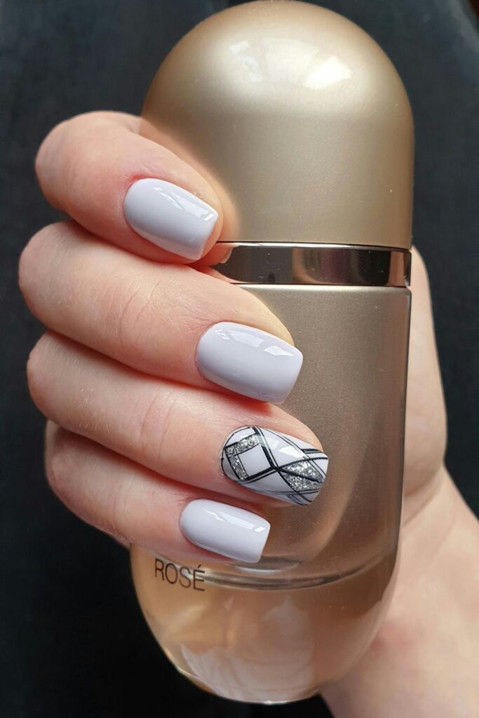 10 Easy Nail Art Ideas for Beginners You Can Try at Home 8 Easy Nail Art featuring glossy white nails with a silver and black geometric accent design.