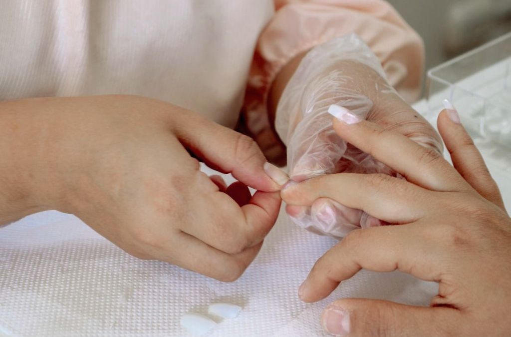Nail tips nails preparation with a nail technician working on a client's fingernails.